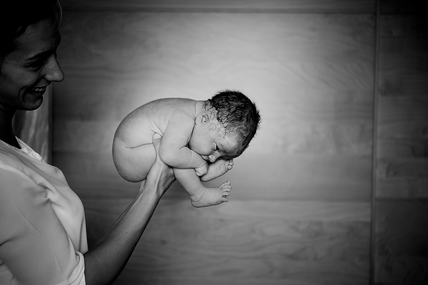 Verloskundige houdt een pasgeboren baby vast
