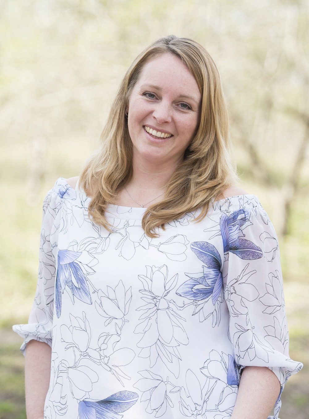 Midwife Marjon Koster-Zeestraten outside in a floral dress