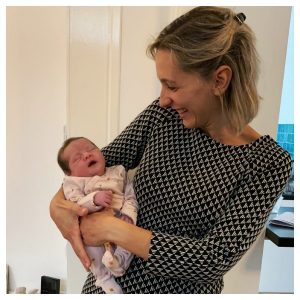 Verloskundige houdt een pasgeboren baby in haar armen