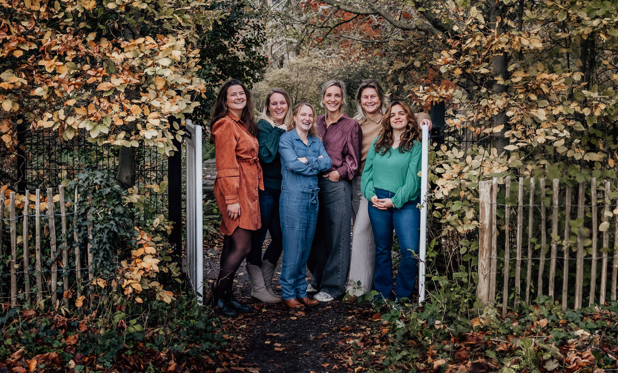 Het team van Luna Verloskundigen bij een tuinhek in de herfst